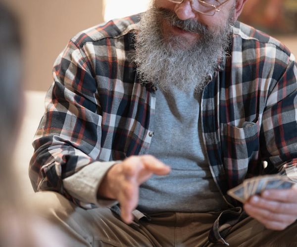Smiling woman stretching gently on a yoga mat at home.